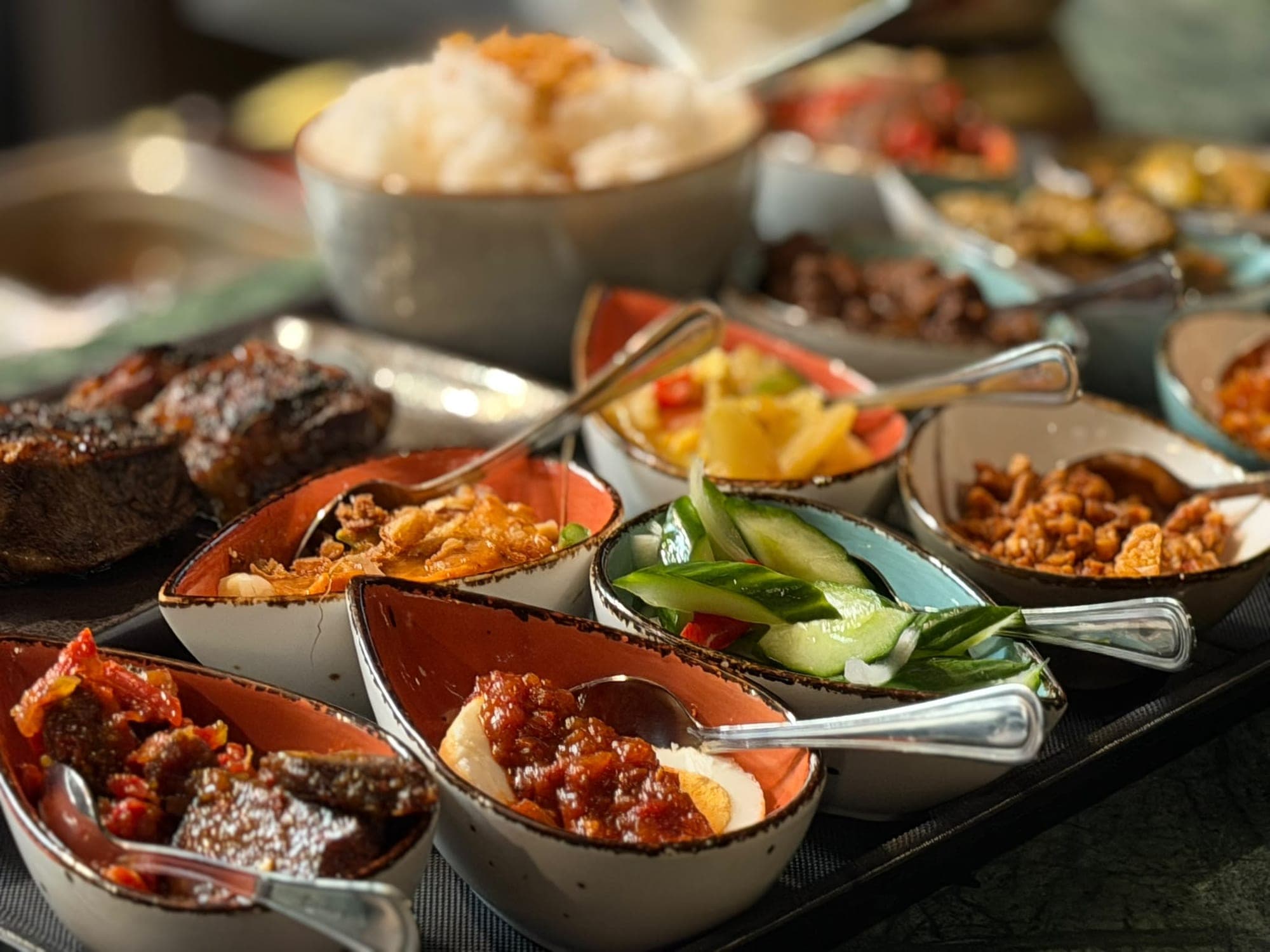 Rijsttafel met witte rijst, vlees van de grill en een reeks kleine bijgerechten